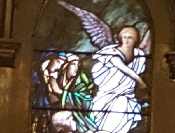 Stained glass window with angel holding child